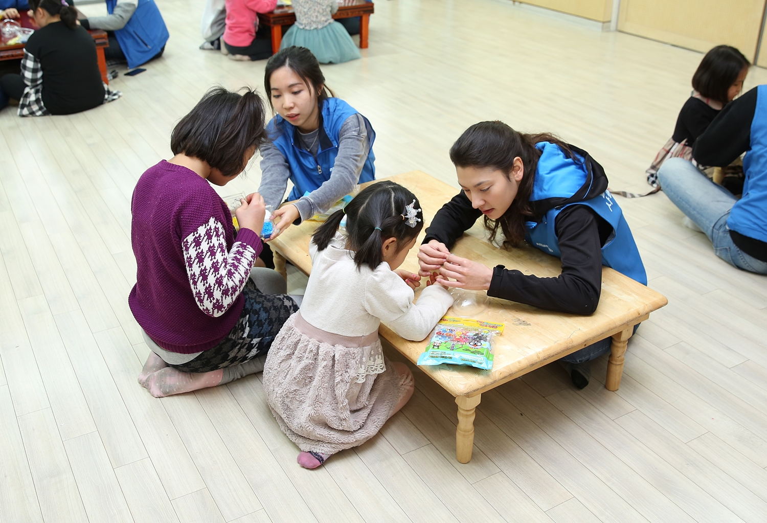 알리안츠생명 직원들이 아이들의 미술놀이 활동을 함께 도와주고 있는 모습의 사진
