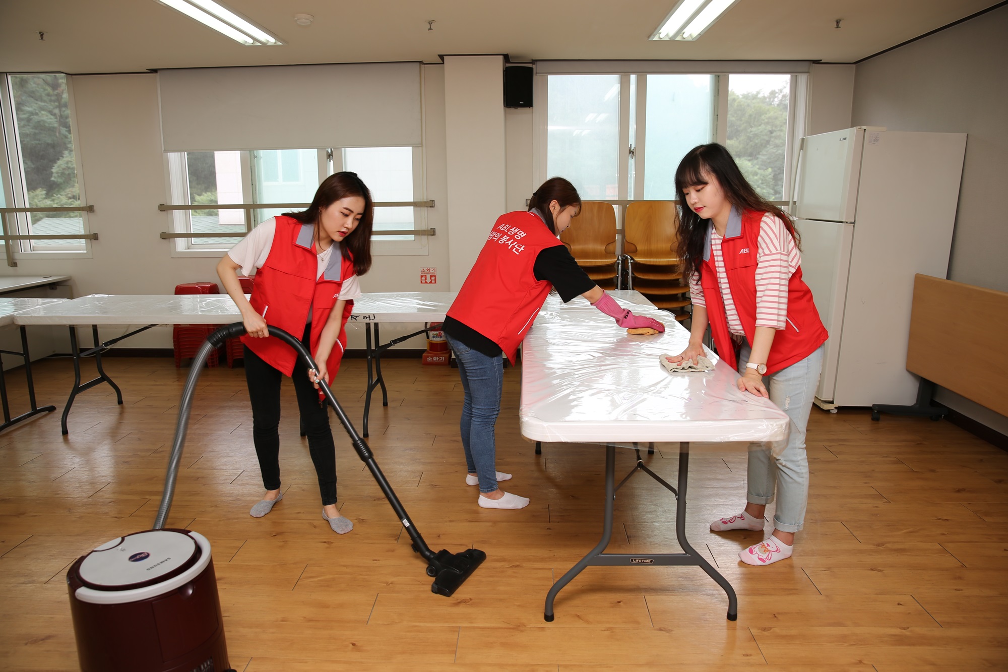 지온보육원 내부를 ABL직원과 인턴학생들이 모여 청소기, 물걸레로 청소를 해주고 있는 모습의 사진