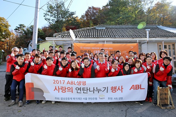 연탄나누기 행사 현수막과 함께 모여 찍은 단체 사진