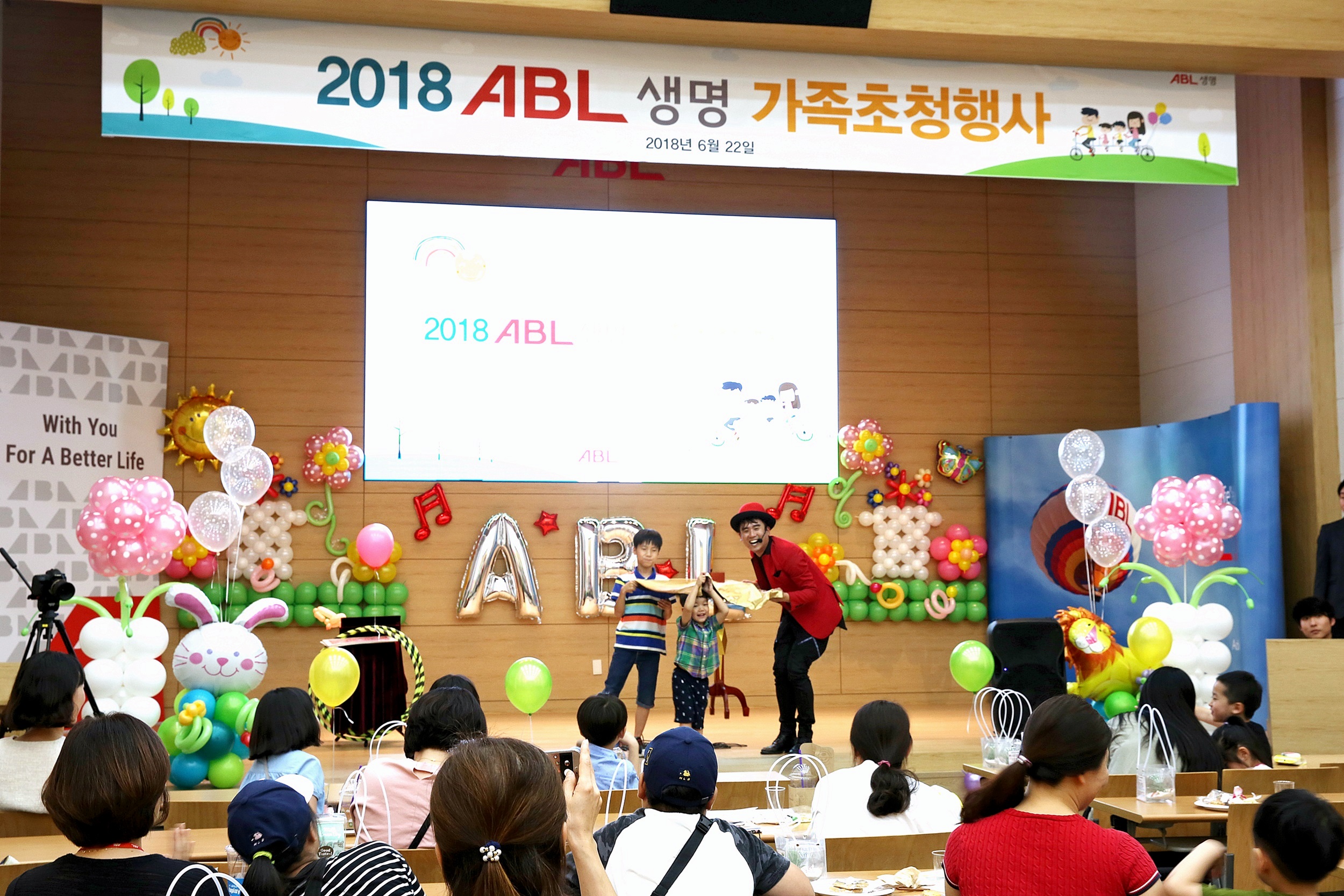 2018 ABL생명 가족초청행사에 사회자가 두 아이를 무대위로 불러 마술쇼를 하고 있는 사진