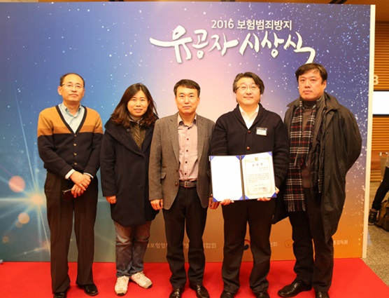2016 보험범죄방지 유공자 선정 시상식에 백승호 계약심사부 차장이 상장을 들고 사람들과 사진을 찍기위해 서있는 모습