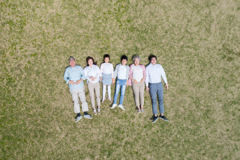 6명의 가족이 풀밭에서 편안하게 누워있는 이미지(할아버지, 할머니, 엄마, 아빠, 아들, 딸)